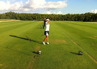 Golfspielerin auf dem Golfplatz macht Abschlag