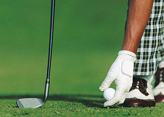 Golfspieler legt Golfball auf den Rasen