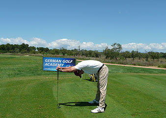 Golfspieler dehnt Rückenmuskulatur auf dem Golfplatz