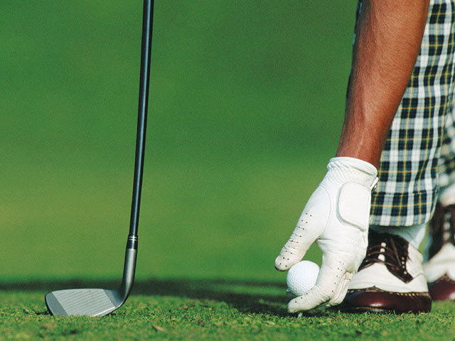 German Golf Academy Platzreife Golfspieler legt Golfball auf den Rasen